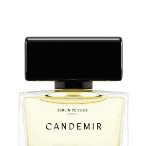 Klassisch-eleganter rechteckiger Parf&uuml;mflakon aus Glas (6 cm breit, 4cm hoch und 3cm tief - Gesamth&ouml;he mit Deckel 7cm) von BERLIN DE VOUS. Gef&uuml;llt mit 30ml des Parfums "CANDEMIR", einer sonnengelben, leuchtenden Fl&uuml;ssigkeit. Der Markenname und der Name des Dufts sind prominent in einer klassisch modernen Schrift schwarz auf dem Glasflakon zentriert. Der Verschluss ist gro&szlig;, ebenfalls rechteckig und aus gl&auml;nzend schwarzem Kunststoff. Er bildet einen starken Kontrast zum hellen Inhalt des Flakons.